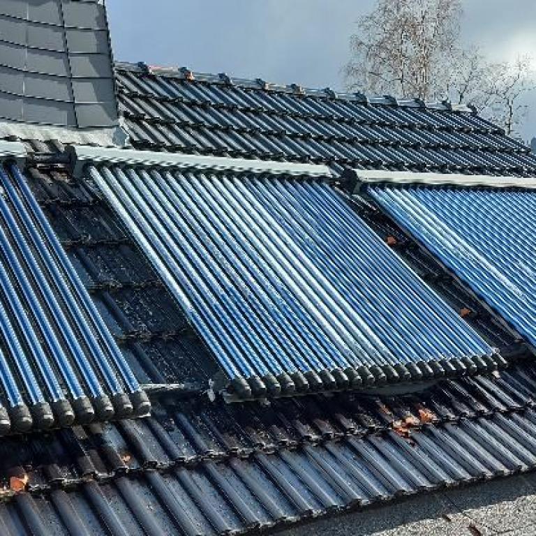 Zu sehen sind Solar Röhrenkollektoren auf einem Dach montiert