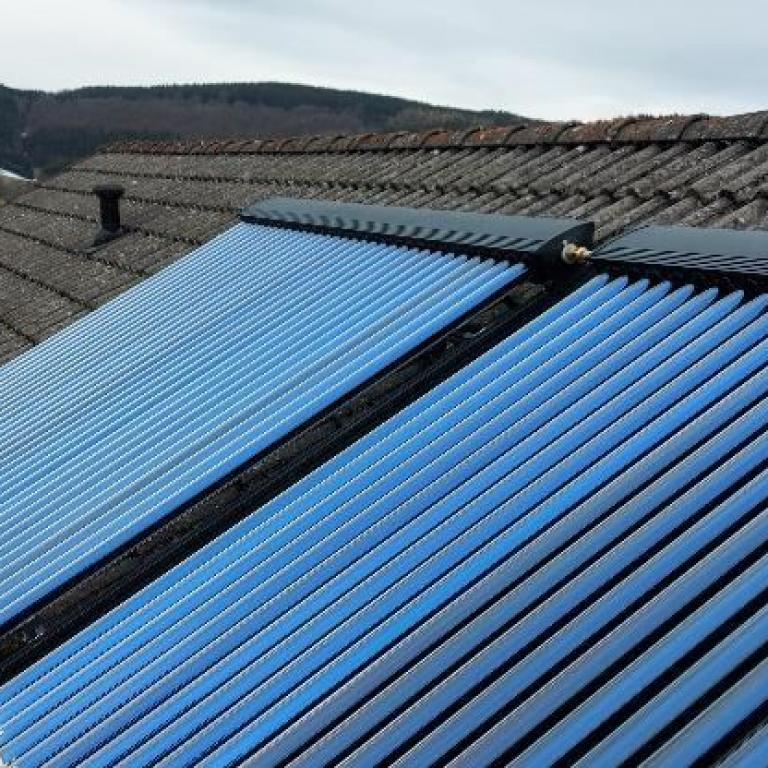 Zu sehen sind Solar Röhrenkollektoren auf einem Dach montiert